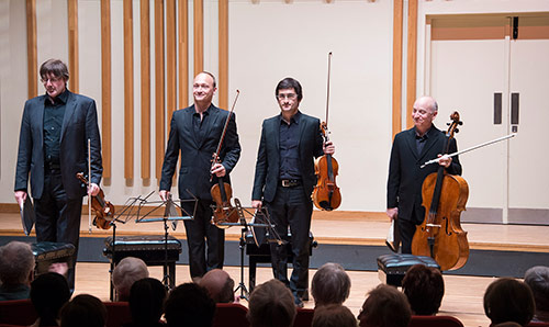 The Quatuor Danel ensemble string quartet standing with their instruments