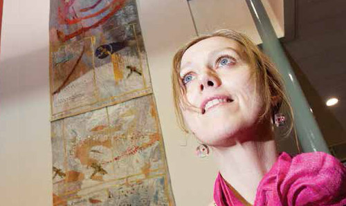 Artist Alice Kettle in front of one of her textile pieces