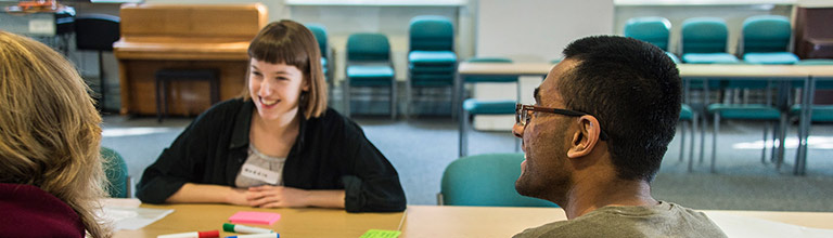 Students sitting at a table with marker pens and post-it notes in room G16 of the Martin Harris Centre