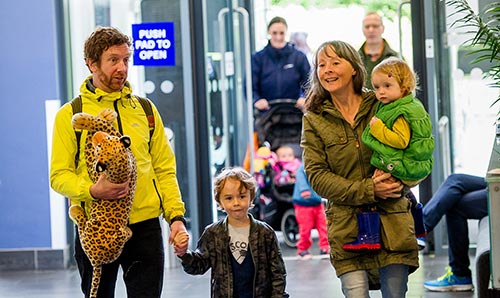 A family walking in through the doors